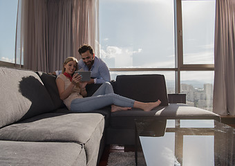 Image showing couple relaxing at  home using tablet computer