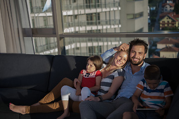 Image showing happy young couple spending time with kids at home