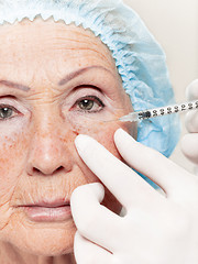 Image showing surgeon doing skin check on mid age woman before plastic surgery