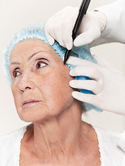 Image showing surgeon doing skin check on mid age woman before plastic surgery