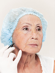 Image showing surgeon doing skin check on mid age woman before plastic surgery