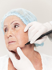 Image showing surgeon doing skin check on mid age woman before plastic surgery