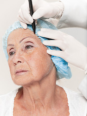 Image showing surgeon doing skin check on mid age woman before plastic surgery