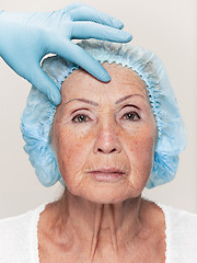 Image showing surgeon doing skin check on mid age woman before plastic surgery