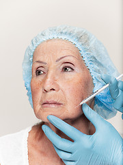 Image showing surgeon doing skin check on mid age woman before plastic surgery