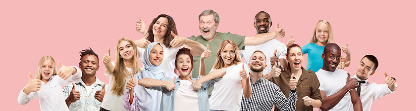 Image showing The happy business women and men standing and smiling against pink background.