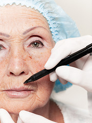 Image showing surgeon doing skin check on mid age woman before plastic surgery