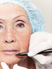 Image showing surgeon doing skin check on mid age woman before plastic surgery