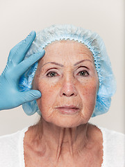 Image showing surgeon doing skin check on mid age woman before plastic surgery