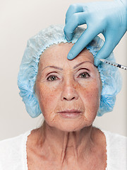 Image showing surgeon doing skin check on mid age woman before plastic surgery