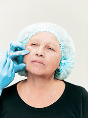 Image showing surgeon doing skin check on mid age woman before plastic surgery