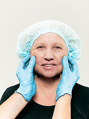 Image showing surgeon doing skin check on mid age woman before plastic surgery