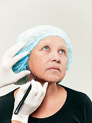 Image showing surgeon doing skin check on mid age woman before plastic surgery