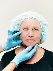 Image showing surgeon doing skin check on mid age woman before plastic surgery