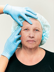 Image showing surgeon doing skin check on mid age woman before plastic surgery