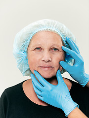Image showing surgeon doing skin check on mid age woman before plastic surgery