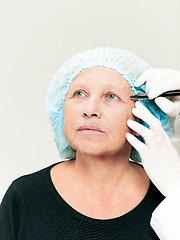 Image showing surgeon doing skin check on mid age woman before plastic surgery