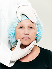 Image showing surgeon doing skin check on mid age woman before plastic surgery