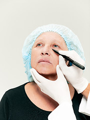 Image showing surgeon doing skin check on mid age woman before plastic surgery