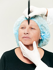 Image showing surgeon doing skin check on mid age woman before plastic surgery