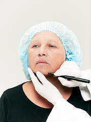 Image showing surgeon doing skin check on mid age woman before plastic surgery