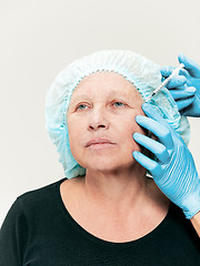 Image showing surgeon doing skin check on mid age woman before plastic surgery