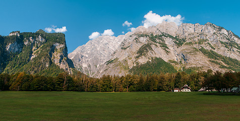 Image showing Idyllic landscape in the Alps with fresh green meadows and blooming flowers and snowcapped mountain tops in the background