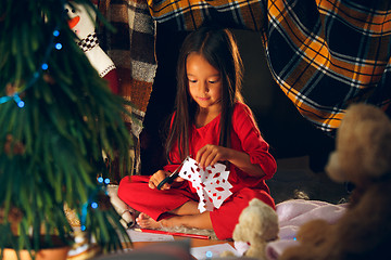 Image showing Beautiful girl holding her hands with snowflakes from the paper