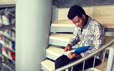 Image showing african student boy or man reading book at library