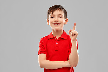 Image showing happy little boy in red t-shirt pointing finger up