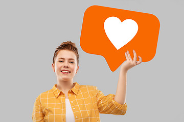 Image showing red haired teenage girl holding heart icon