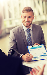 Image showing smiling businessman with graph at business meeting