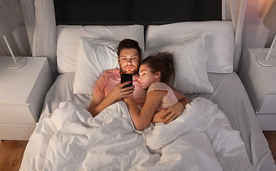 Image showing man using smartphone while girlfriend is sleeping