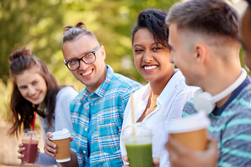 Image showing friends drinking coffee and juice talking in park