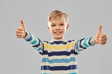Image showing smiling boy in striped pullover showing thumbs up