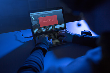 Image showing hands of hacker with access denied message laptop