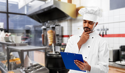 Image showing indian chef with menu on clipboard at kebab shop