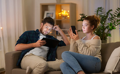 Image showing couple with tablet computer and smartphone at home