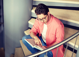 Image showing student boy or young man reading book at library