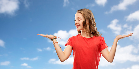 Image showing smiling teenage girl holding empty hand