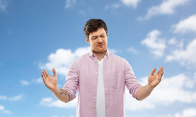 Image showing doubting man showing size of something over sky