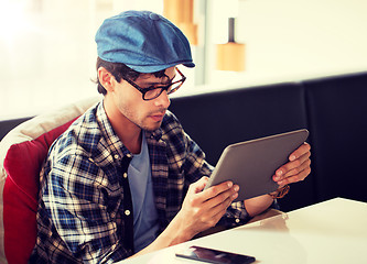 Image showing man with tablet pc sitting at cafe table