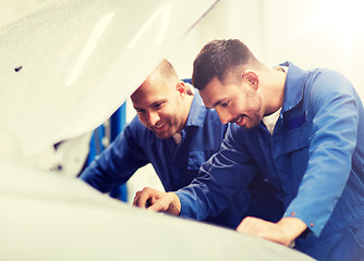 Image showing mechanic men with wrench repairing car at workshop