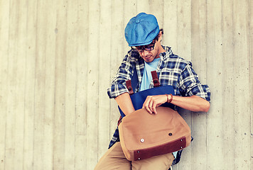 Image showing hipster man looking for something in his bag