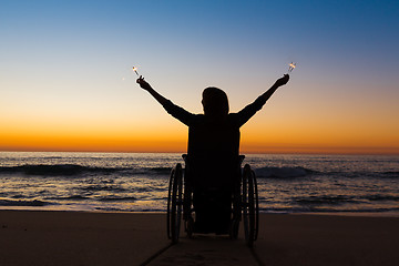 Image showing Handicapped woman holding fire sparklers