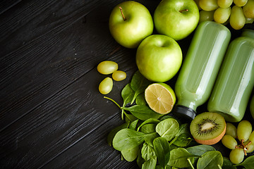 Image showing Mixed green fruits and vegetables placed on black wooden table