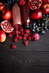 Image showing Various fresh red, purple black fruits. Mix of fruits and bottle