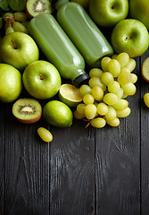 Image showing Mixed green fruits and vegetables placed on black wooden table