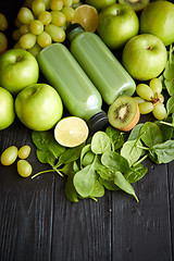 Image showing Mixed green fruits and vegetables placed on black wooden table