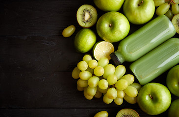 Image showing Mixed green fruits and vegetables placed on black wooden table